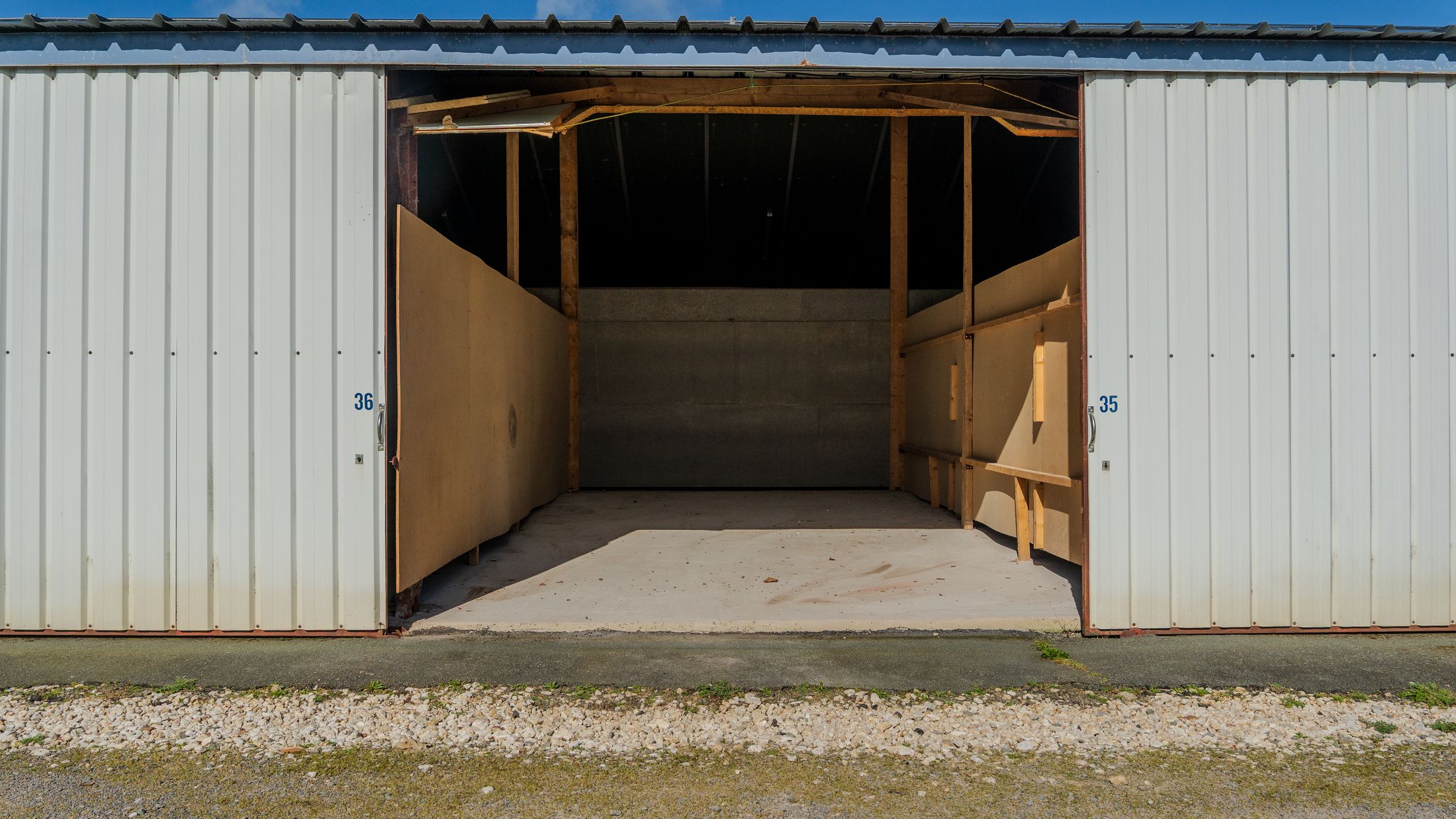 Box de stockage ouvert, sol béton et parois bois